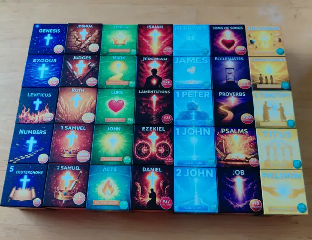 Kingdom Cubes laid out in rows showing color-coded cover faces from Genesis to Philemon